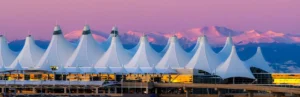 The iconic white peaked roof of Denver International Airport at sunset, a primary destination for our Denver airport car service.